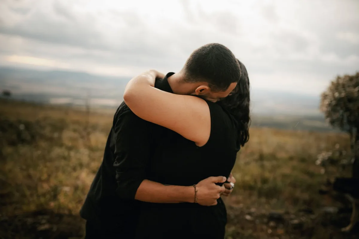 A couple embracing affectionately outdoors.